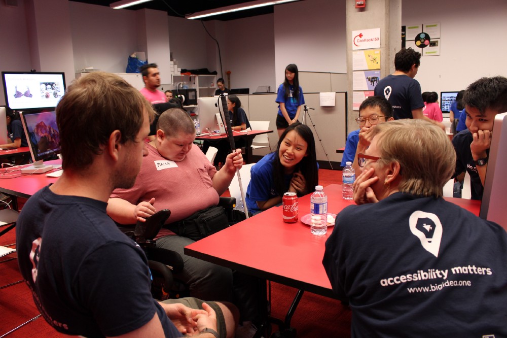 Diverse individuals collaborate at a table. A t-shirt slogan reads Accessibility Matters.